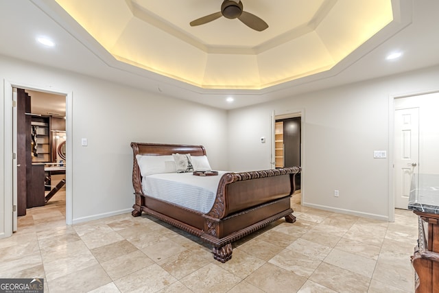 bedroom featuring a raised ceiling and ceiling fan