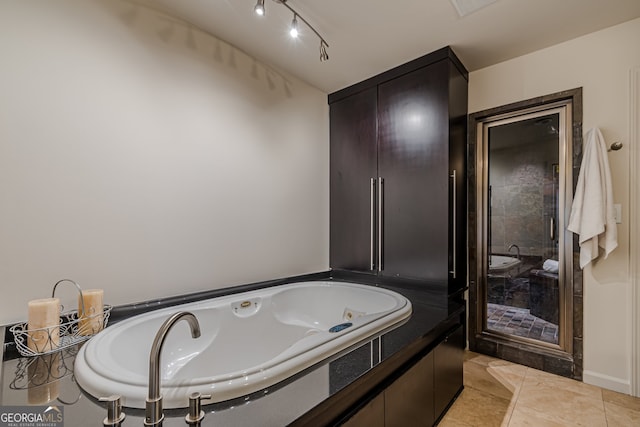 bathroom with a tub to relax in and tile patterned floors