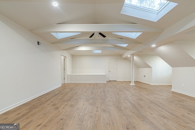 additional living space featuring vaulted ceiling with beams and light wood-type flooring