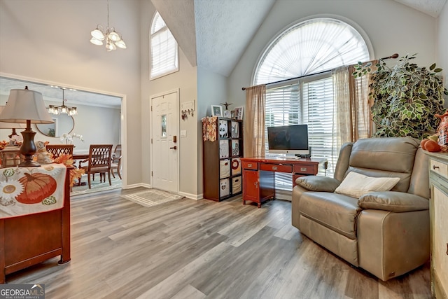 entryway with wood-type flooring, an inviting chandelier, and plenty of natural light