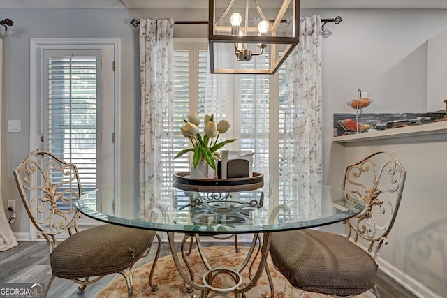 dining area featuring hardwood / wood-style floors and an inviting chandelier