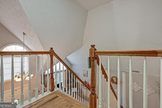 stairs with an inviting chandelier