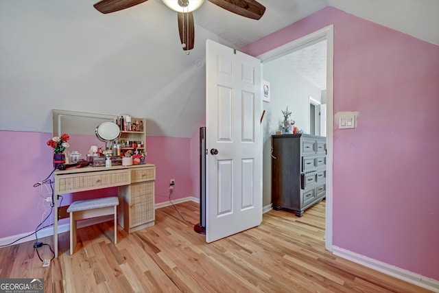 home office featuring a textured ceiling, ceiling fan, light hardwood / wood-style flooring, and lofted ceiling