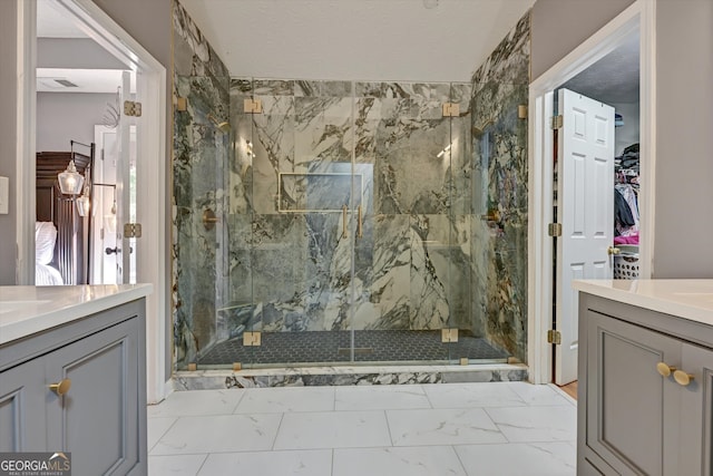 bathroom with a tile shower, vanity, and a textured ceiling