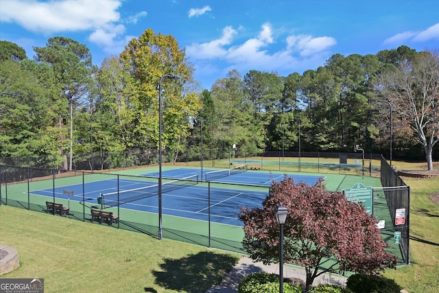 view of tennis court featuring a yard