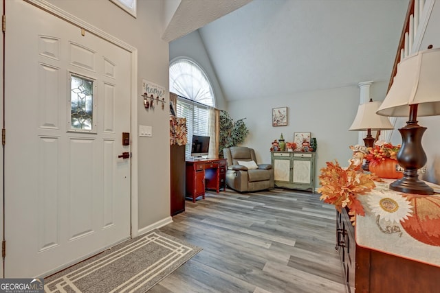 foyer with light hardwood / wood-style flooring and lofted ceiling