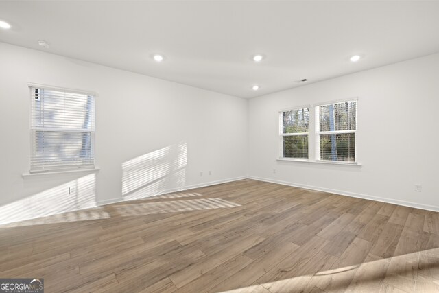 kitchen with light stone countertops, white cabinetry, sink, appliances with stainless steel finishes, and light wood-type flooring