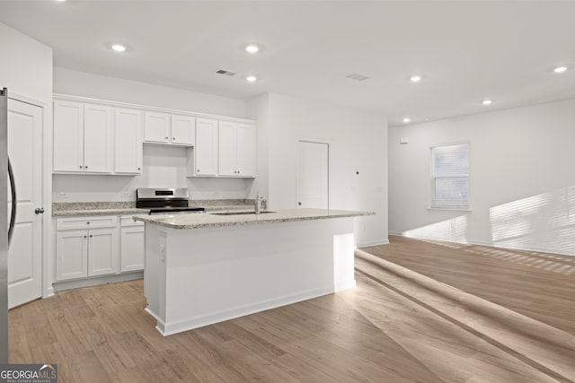 kitchen with white cabinetry, an island with sink, and appliances with stainless steel finishes