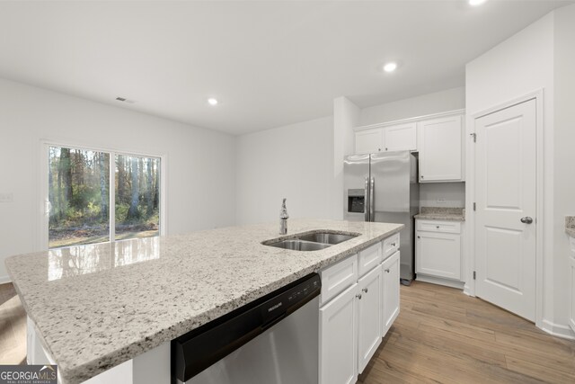 kitchen featuring a kitchen breakfast bar, an island with sink, appliances with stainless steel finishes, light hardwood / wood-style floors, and white cabinetry