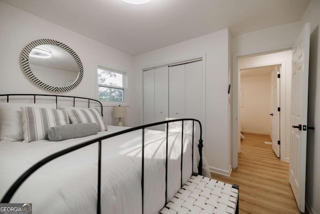 bedroom with light hardwood / wood-style floors and a closet