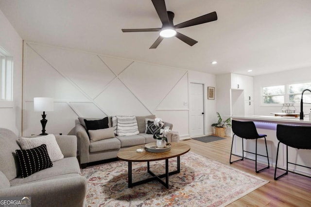 living room with ceiling fan and light hardwood / wood-style floors