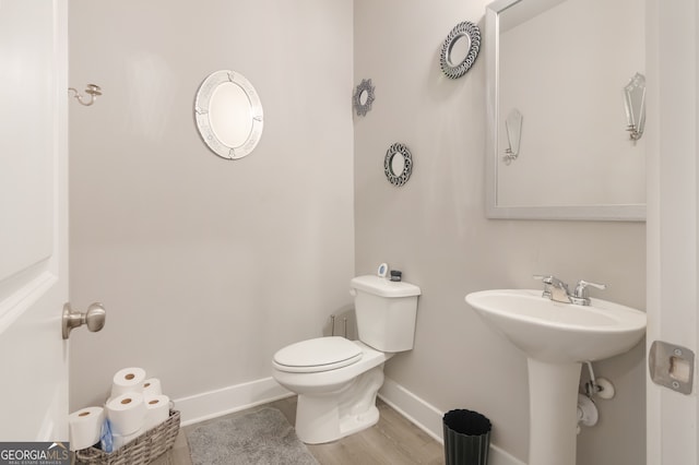 bathroom with toilet and wood-type flooring