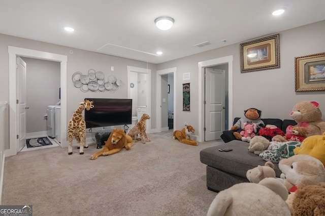 carpeted living room featuring independent washer and dryer