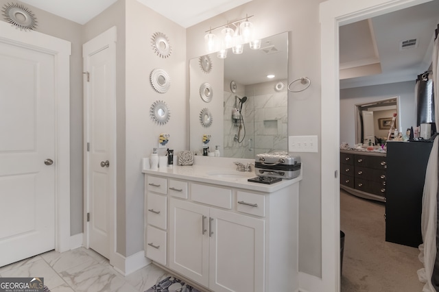 bathroom with tiled shower and vanity