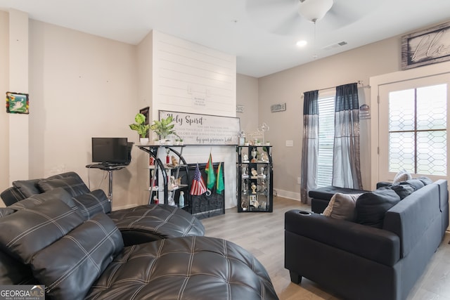 living room featuring ceiling fan and light hardwood / wood-style floors