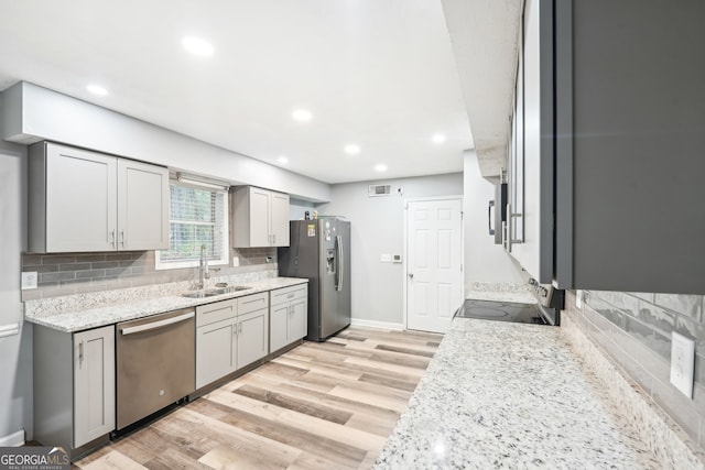 kitchen featuring gray cabinets, sink, stainless steel appliances, and light hardwood / wood-style flooring