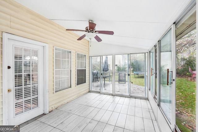 unfurnished sunroom with ceiling fan, a healthy amount of sunlight, and lofted ceiling