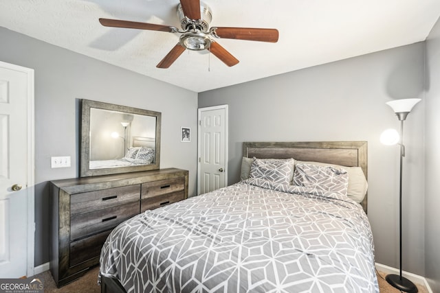 carpeted bedroom featuring ceiling fan and a textured ceiling