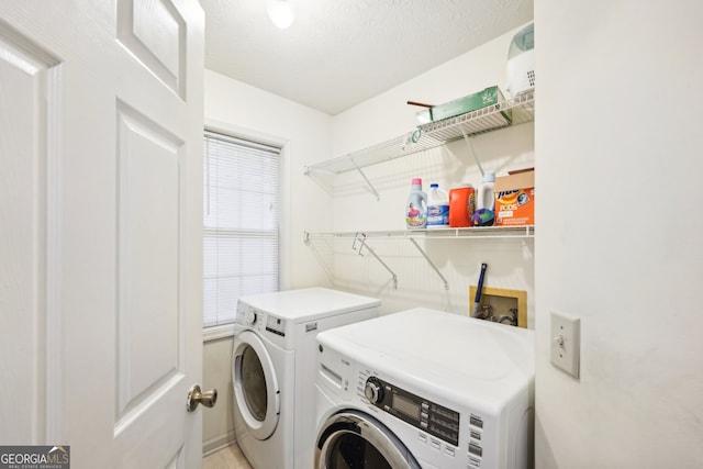 clothes washing area with a textured ceiling and washer and clothes dryer