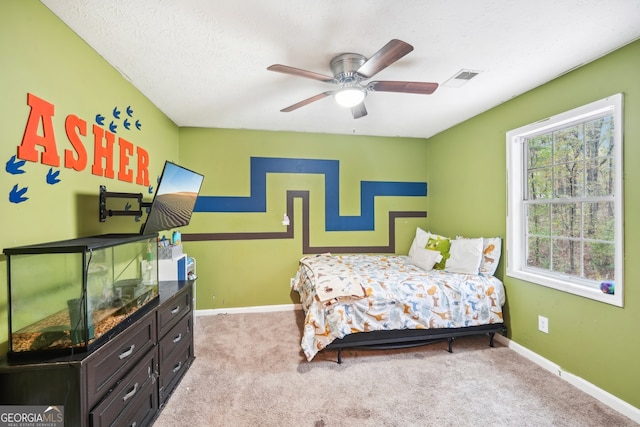 bedroom featuring a textured ceiling, ceiling fan, and light carpet