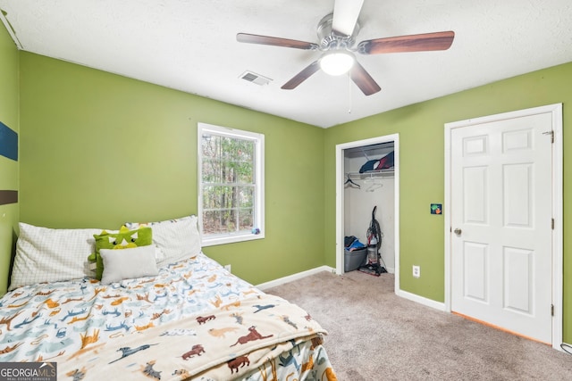 carpeted bedroom with ceiling fan, a closet, and a textured ceiling