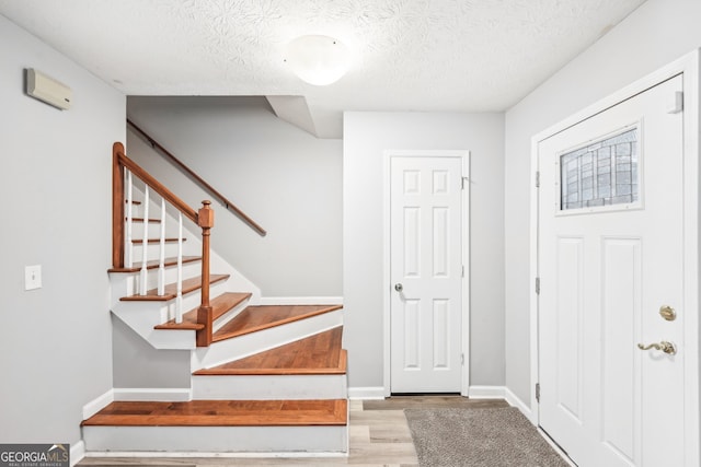 foyer with light hardwood / wood-style flooring and a textured ceiling