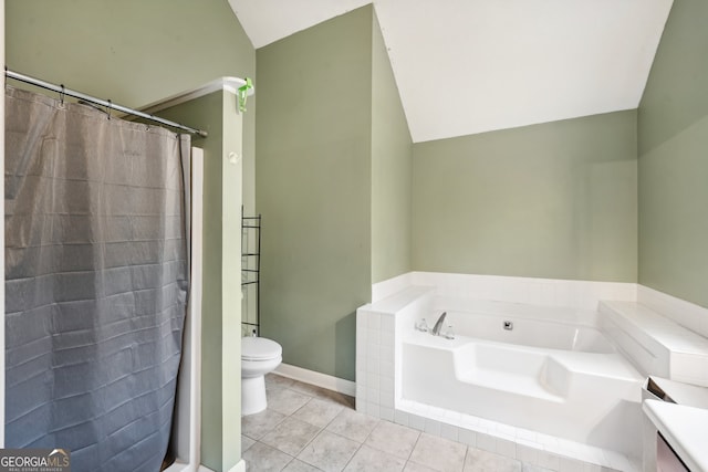 bathroom featuring tile patterned floors, vanity, vaulted ceiling, tiled bath, and toilet