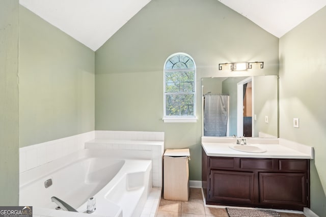 bathroom with tile patterned flooring, vanity, a relaxing tiled tub, and lofted ceiling