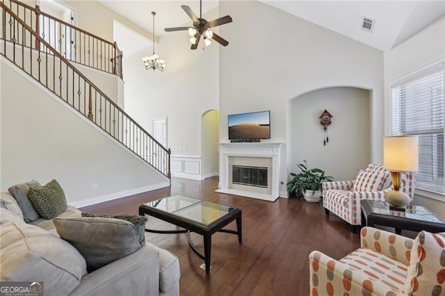 living room with high vaulted ceiling, ceiling fan, and dark wood-type flooring