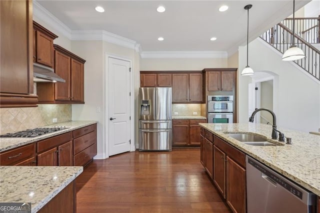 kitchen featuring sink, stainless steel appliances, light stone counters, dark hardwood / wood-style floors, and pendant lighting