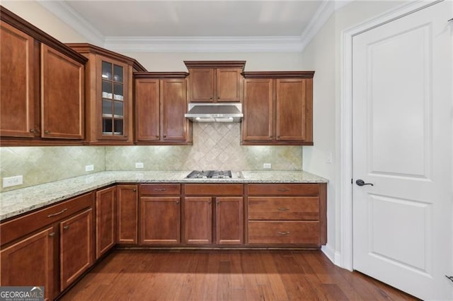 kitchen featuring stainless steel gas stovetop, dark wood-type flooring, decorative backsplash, ornamental molding, and light stone counters