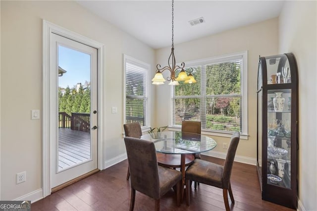 dining room with dark hardwood / wood-style flooring and a notable chandelier