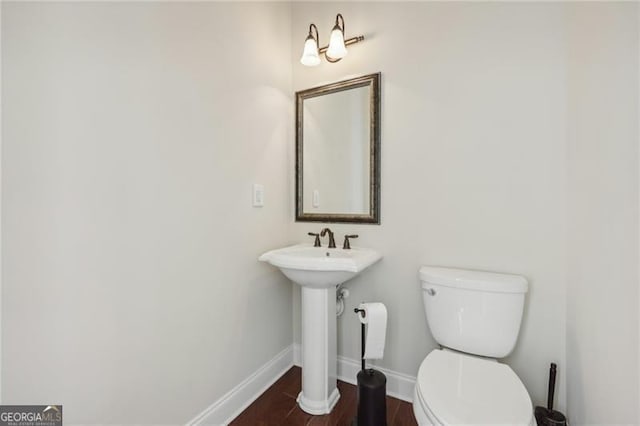 bathroom with hardwood / wood-style floors and toilet