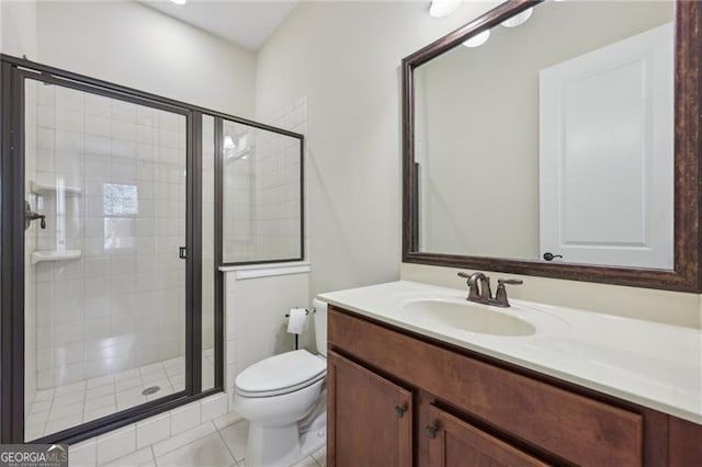 bathroom featuring tile patterned flooring, vanity, toilet, and walk in shower