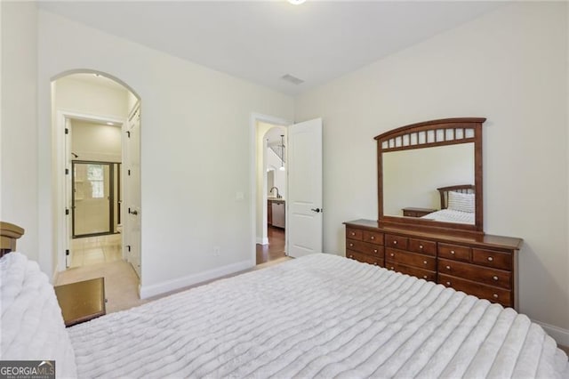 bedroom with light colored carpet and ensuite bath