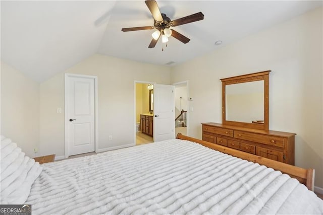 bedroom featuring connected bathroom, light colored carpet, vaulted ceiling, and ceiling fan