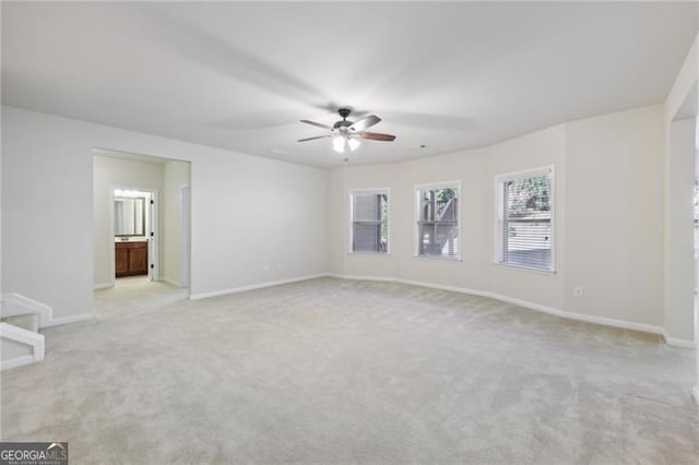 spare room featuring light carpet and ceiling fan