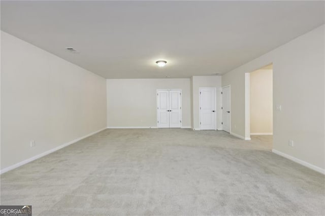 unfurnished room featuring light colored carpet