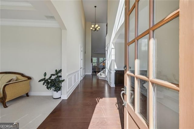 hallway featuring crown molding, dark hardwood / wood-style floors, and a notable chandelier