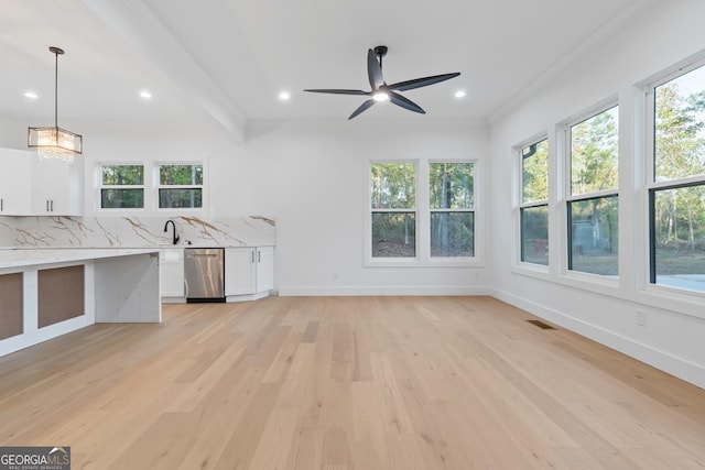 interior space featuring stainless steel dishwasher, hanging light fixtures, light stone countertops, white cabinets, and ceiling fan with notable chandelier