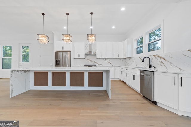 kitchen with backsplash, a center island, sink, stainless steel appliances, and white cabinets