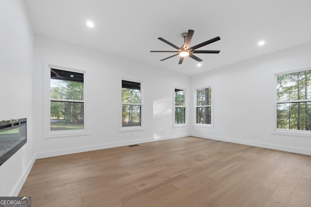 spare room with ceiling fan and light wood-type flooring