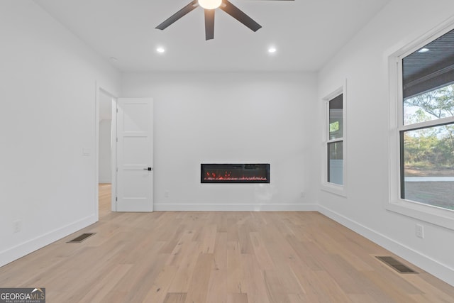 unfurnished living room featuring ceiling fan and light hardwood / wood-style flooring