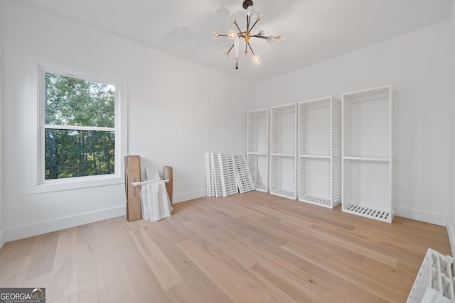 unfurnished bedroom featuring light hardwood / wood-style floors and a chandelier