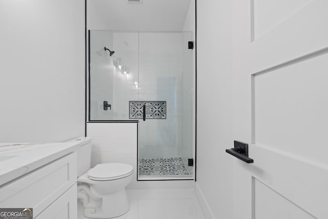 bathroom featuring toilet, vanity, tile patterned floors, and a shower with door