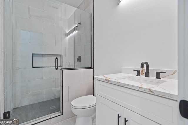 bathroom with toilet, vanity, tile patterned floors, and walk in shower