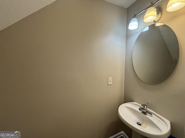 bathroom with sink and a textured ceiling