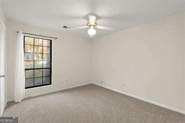 spare room with ceiling fan and light carpet