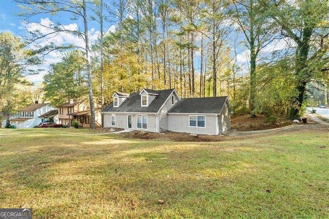 cape cod home featuring a front lawn