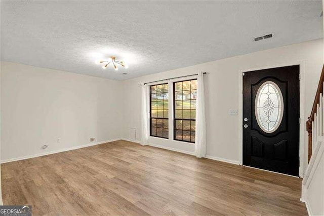 entrance foyer with wood-type flooring and a textured ceiling